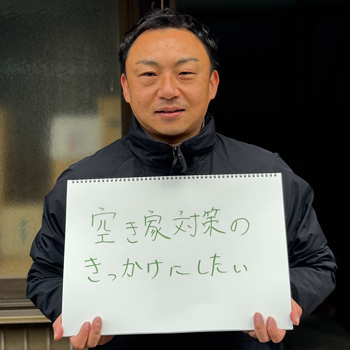 篠原 啓行さんが手書きのメッセージボードを持つ写真